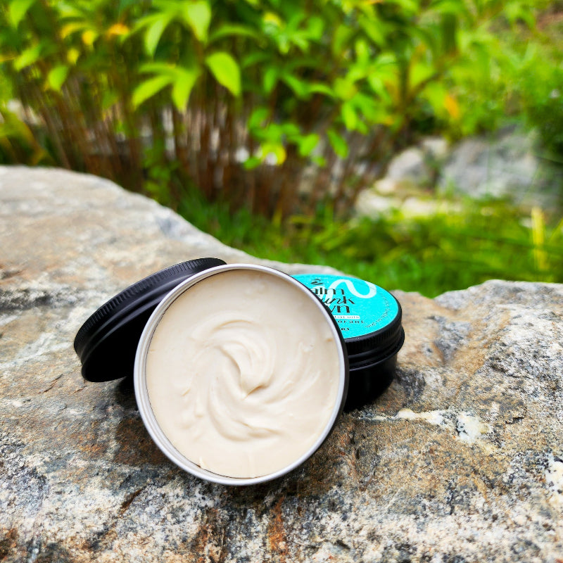 2 jars of natural deodorant 'Calm the Funk Down' on a big rock, one jar opened