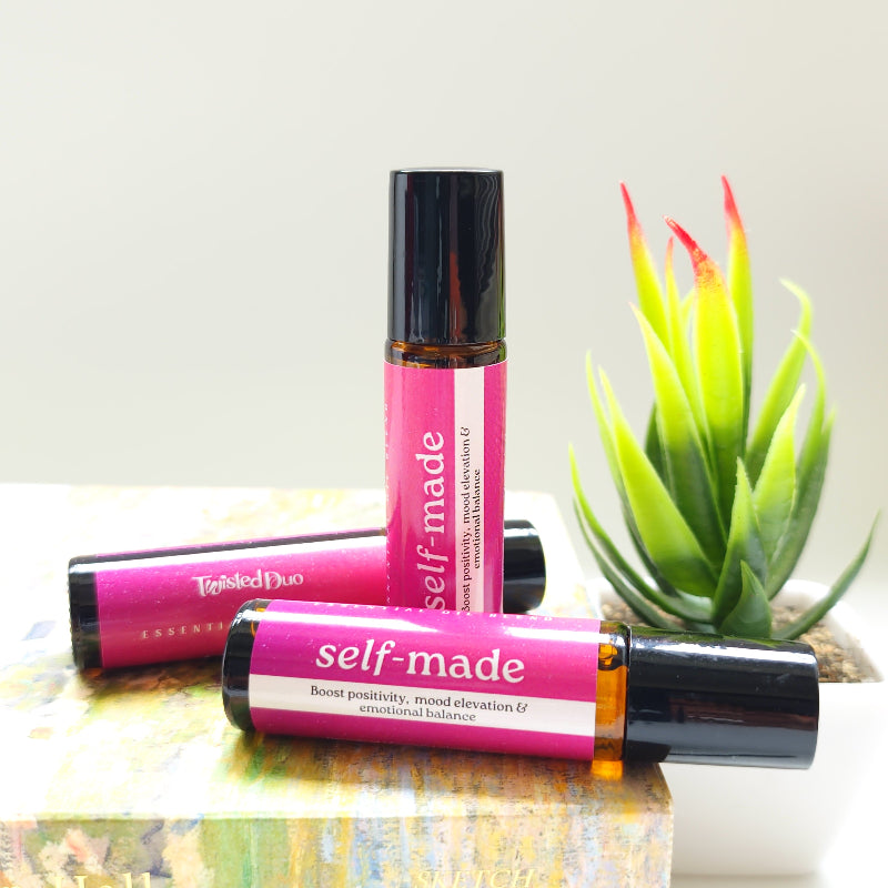Two 'self-made' roller blend on a white surface with a plant in the background