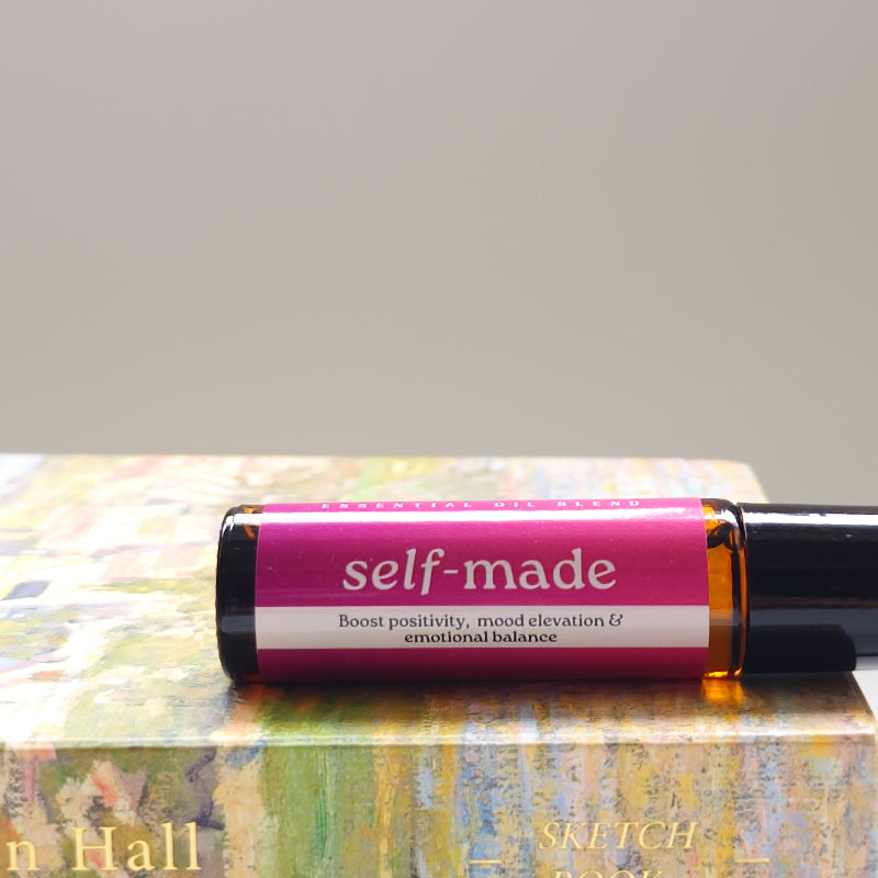 Roll-on bottle labeled 'self-made' with a colorful box in the background